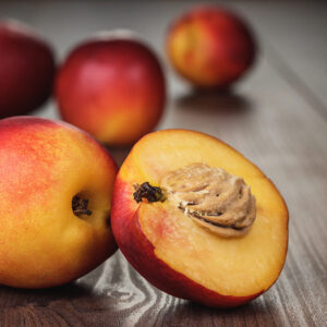 Some fresh nectarines over brown wooden background.