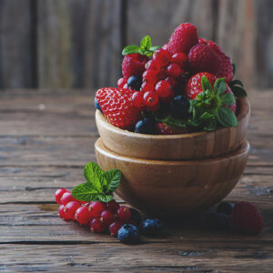 Mix of red fruits on a wooden table.