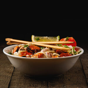 Noodles with seafood on wooden table.